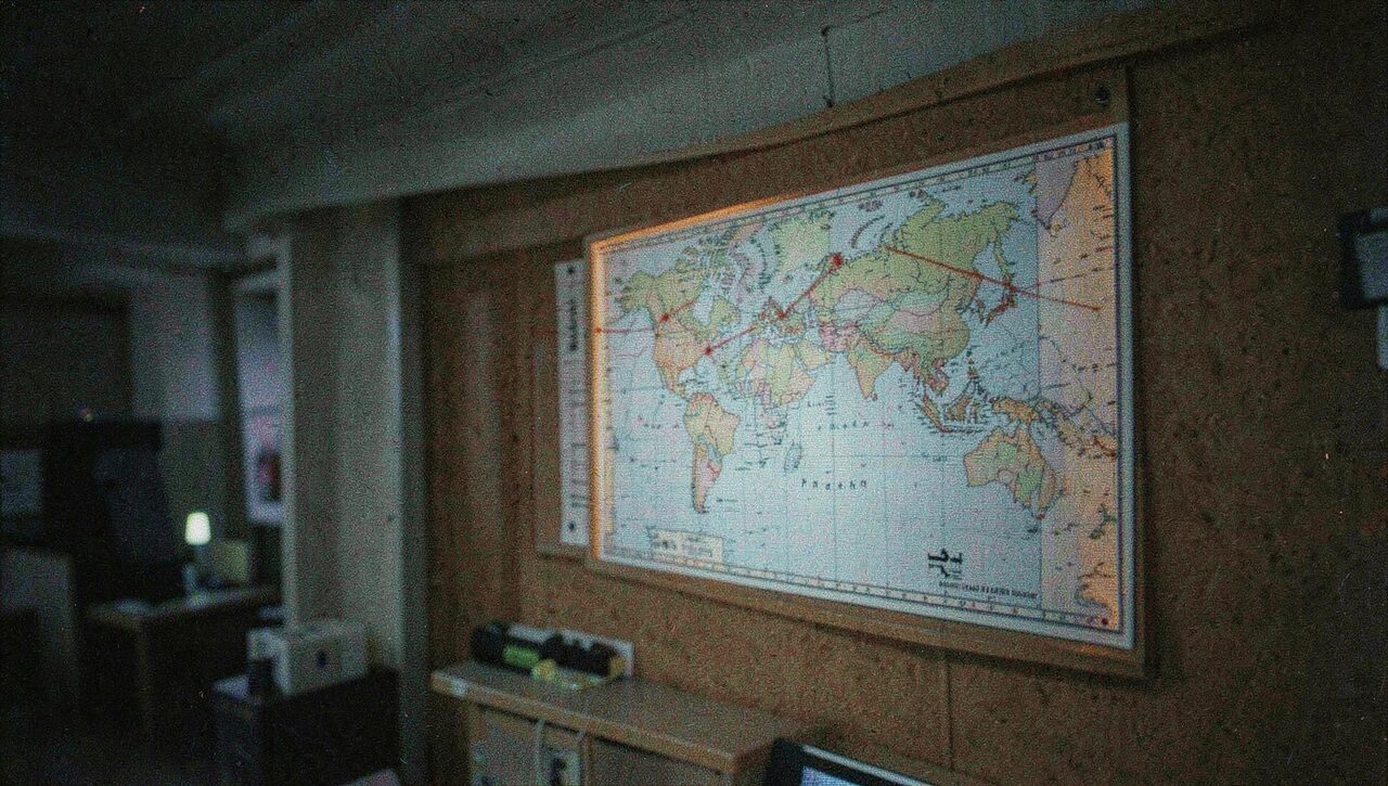 A world map pinned to a corkboard with red string. The reports do not respect borders, which is part of the problem.