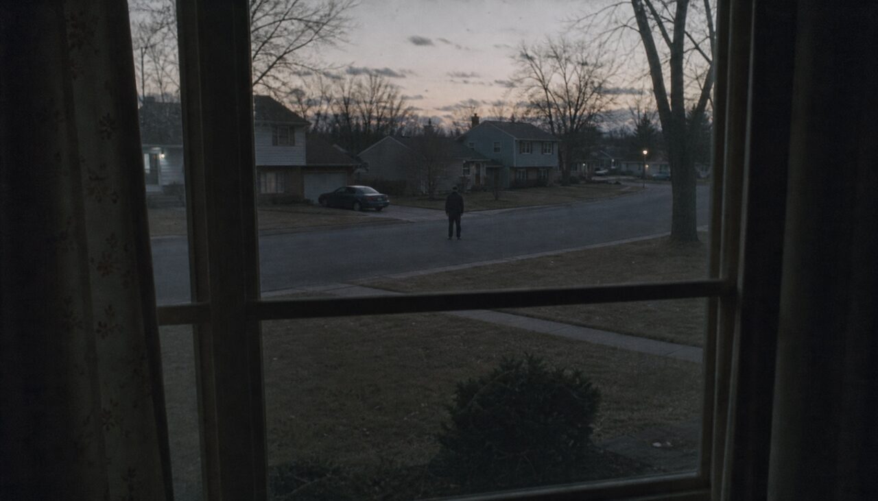 A figure in the road at dusk, seen through a window. Everything after this is a copy of it.