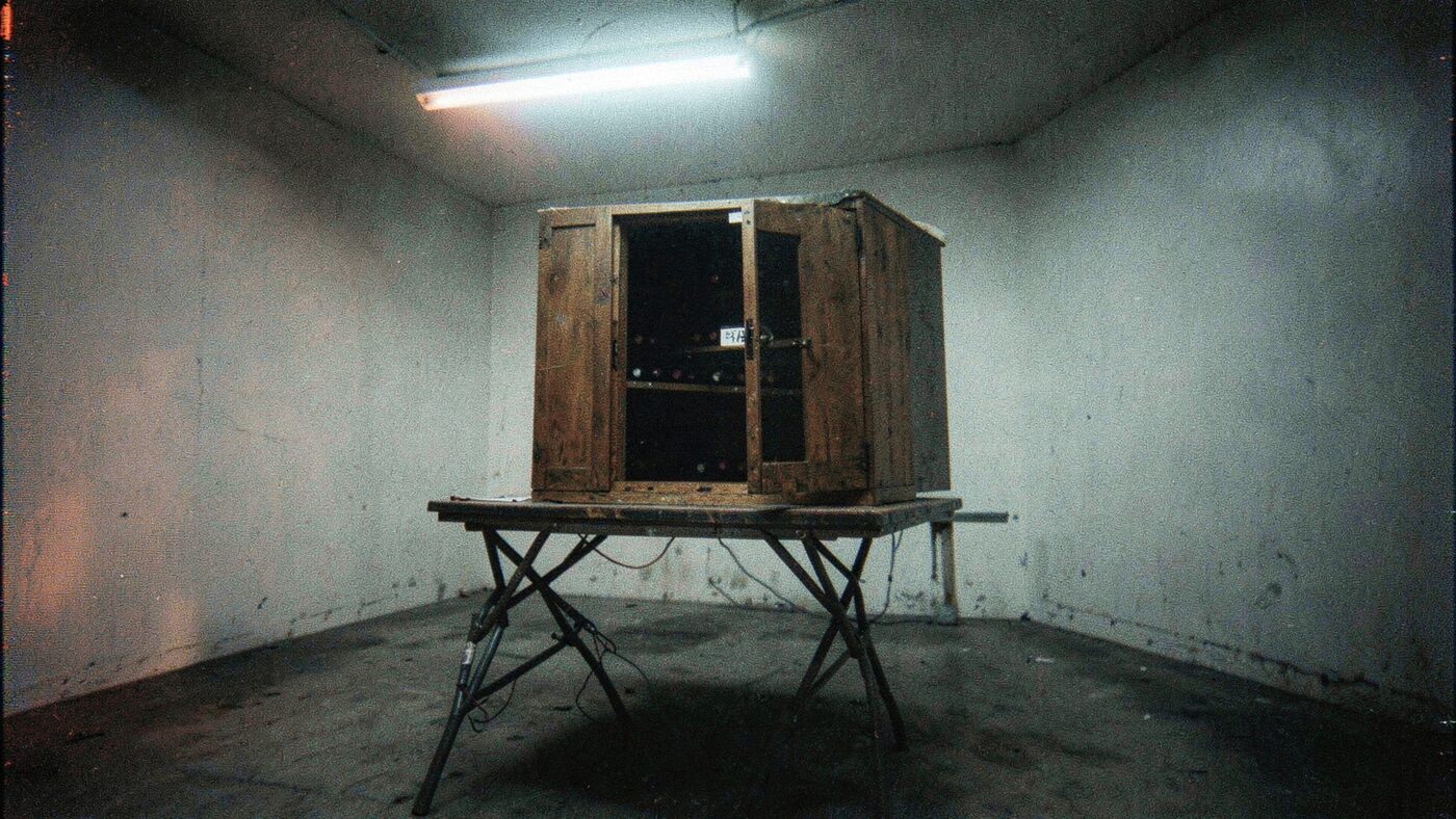 The object itself, doors open: a secondhand wine cabinet with a rack and a handwritten price tag. Everything else was added later.